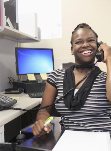 Teen with a Cognitive Disorder talking on phone in an office