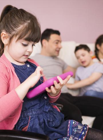 Girl with Down Syndrome in wheelchair using digital tablet